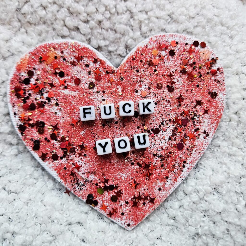Aimant en forme de coeur décoré avec des paillettes rouges et des perles avec inscription "Fuck you"