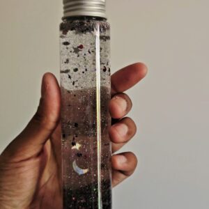 Bouteille sensorielle avec des paillettes fines, étoiles, Lunes argentées et des obsidiennes noires