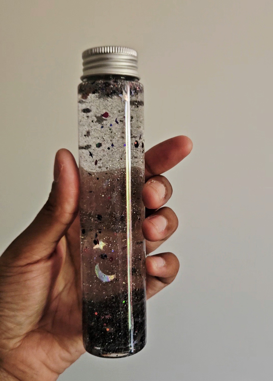Bouteille sensorielle avec des paillettes fines, étoiles, Lunes argentées et des obsidiennes noires